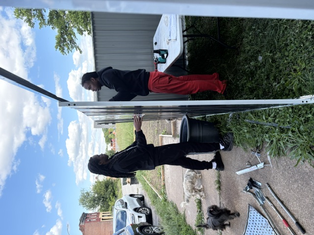 Kahlil and youth building the shed together